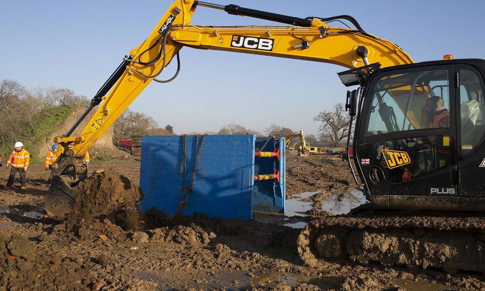 A Trench box with lifting chains while a trench is being dug on a construction site